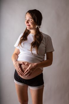 Pregnant woman touching belly close-up