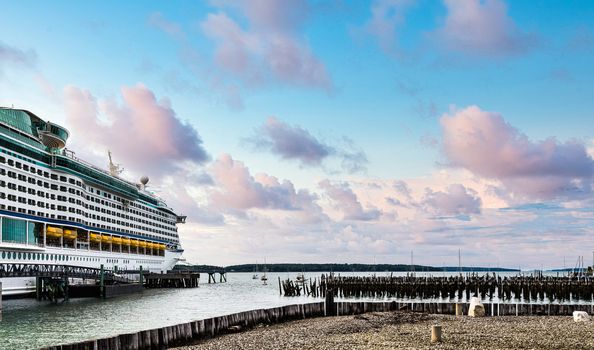 Huge Luxury cruise ship in Portland, Maine by old wood pilings