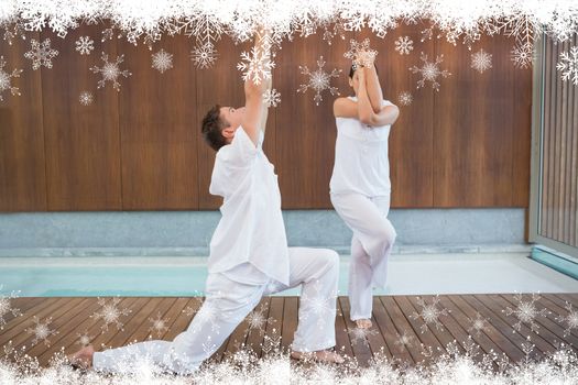 Peaceful couple in white doing yoga together against fir tree forest and snowflakes