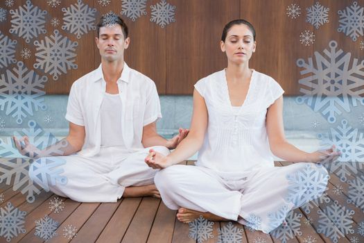 Attractive couple in white meditating in lotus pose against snowflake frame