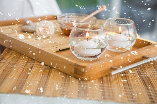 Candles and beauty treatment on tray against snow falling