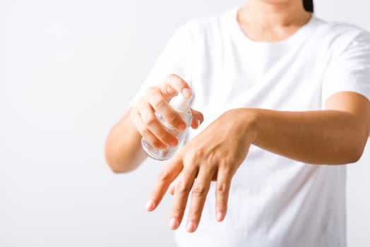 Closeup Hand Asian young woman applying spray pump dispenser sanitizer alcohol on back hand wash cleaning, hygiene prevention COVID-19 or coronavirus protection concept, isolated on white background