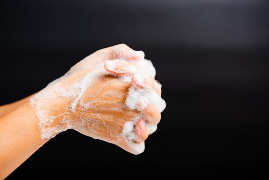 Closeup body care Asian young woman washing hands with soap have foam, hygiene prevention COVID-19 or coronavirus protection concept, isolated on black background