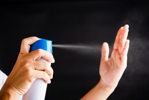 Closeup Hand Asian young woman applying spray pump dispenser sanitizer alcohol on hand wash cleaning, hygiene prevention COVID-19 or coronavirus protection concept, isolated on black background