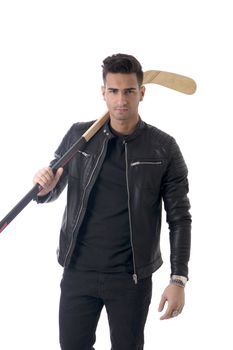 Portrait of a handsome man in blue hoodie posing for camera with hockey stick in his hands