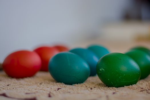 Red, blue and green rows of colorful Еaster eggs waiting for their paint to dry.