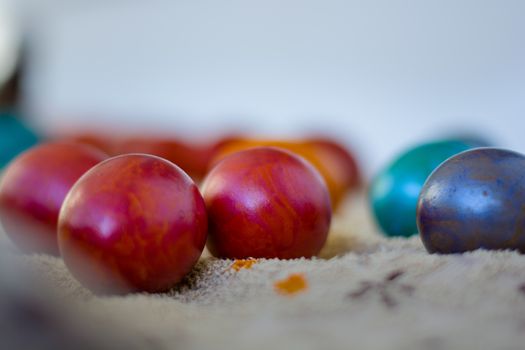 A close image of many colorful Еaster eggs waiting for their paint to dry.