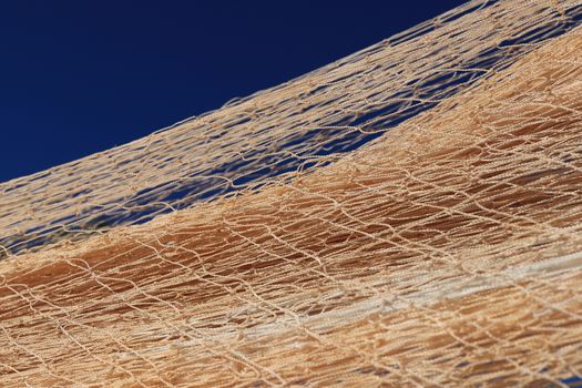 Nylon fishnet texture on the clear sky. Nautical marine background. Macro closeup.