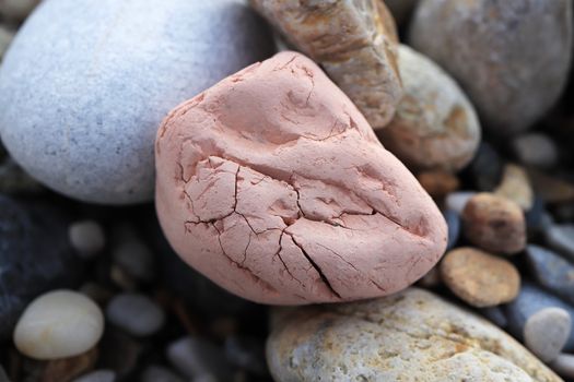 Pink stone with cobblestones on the beach.