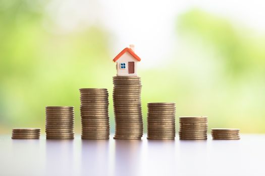 House placed on coins  is planning savings money of coins to buy a home concept concept for property ladder, mortgage. Saving money concept, coin stack growing business, save money for investment.