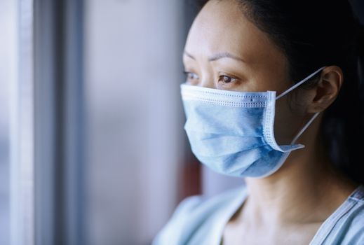 Woman staying at home wearing protective surgical mask