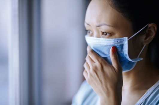 Woman staying at home wearing protective surgical mask