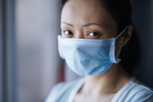 Woman staying at home wearing protective surgical mask