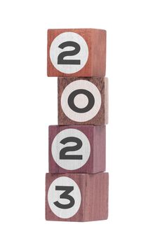 Four isolated hardwood toy blocks on white, saying 2023