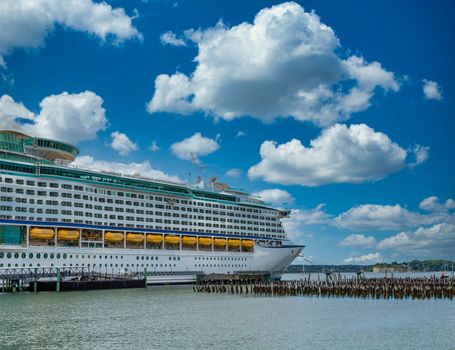 Huge Luxury cruise ship in Portland, Maine by old wood pilings