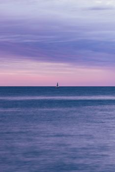 single black and white striped buoy on river at sunrise