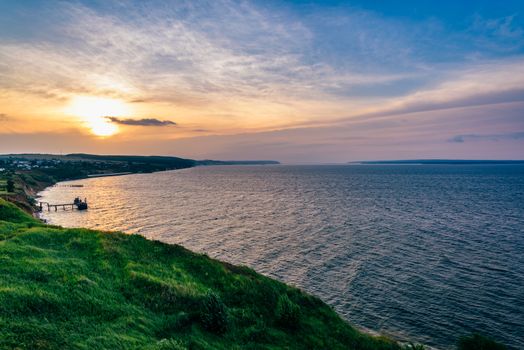 Landscape of hilly shore next to the rivers estuary at sunset light