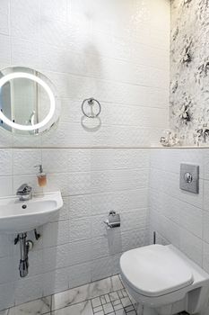 Interior of a modern bright bathroom with a sink and toilet