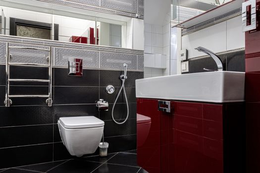 Interior of a modern bathroom with a sink and toilet in gray-red colors