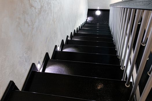 Modern brown wooden staircase with illuminated steps.