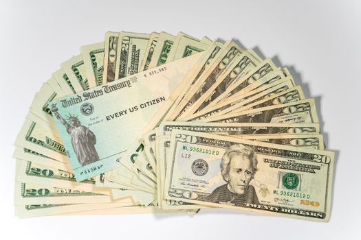 Stack of 20 dollar bills with US Treasure illustrative check to illustrate coronavirus stimulus payment on white background