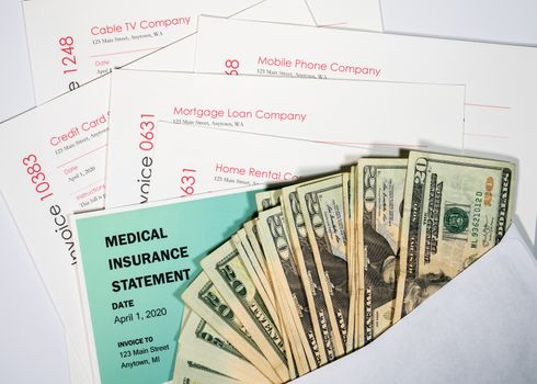 Stack of 20 dollar bills in envelope to illustrate coronavirus stimulus payment being used to pay many past due bills and invoices