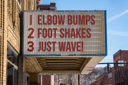 Movie cinema billboard with three rules to replace handshakes with elbow bumps, footshakes or just waving to friend during coronavirus epidemic