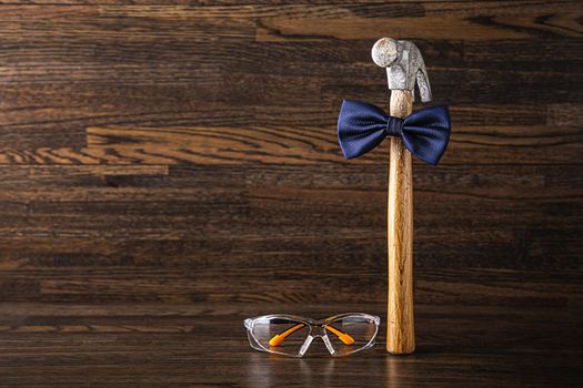 wood handle hammer wearing a bowtie with protective glasses on the side