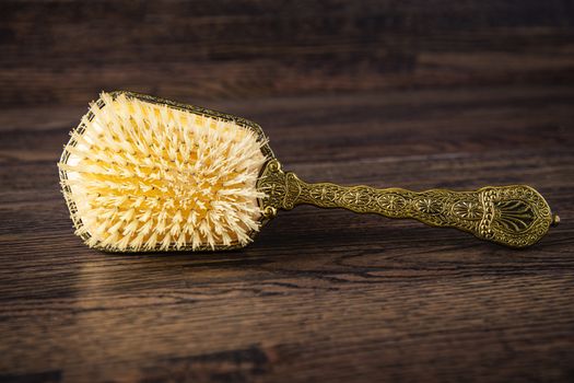 Antique hair brush against a dark wood background