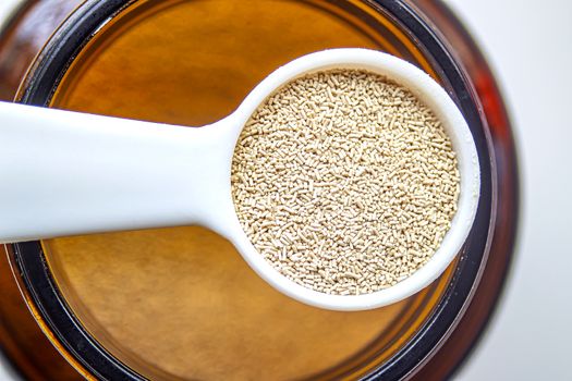 A top view close up of a measurement baking spoons with yeast container