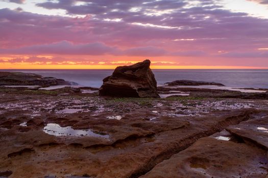 Coastal sunrise skies long exposure along the rocky reef at low tide