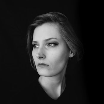 Black and white portrait of a girl on a black background. Powerful energy concept.