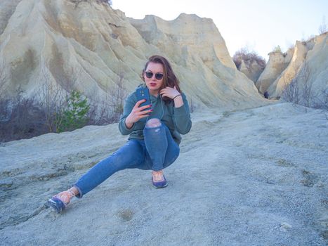 Hiker on mountain top with smartphone. Woman is standing and taking a picture on smartphone. Abandoned Quarry Of Rummu, Estonia. Scenic View Of Land Against Clear Blue Sky. Panoramic View.