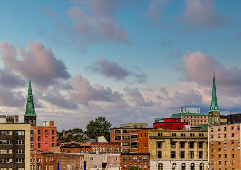 Two green church steeples above old brick buildings in Saint John, New Brunswick, Canada