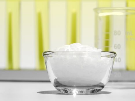 Close up White flake chemical on laboratory table. Cetyl esters wax, Chemical used in OTC products and topical pharmaceuticals.