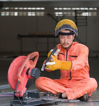 Industrial workers inspect cut steel to the size required by customers. For the real estate project received. Metal grinding on steel spare part in workshop.