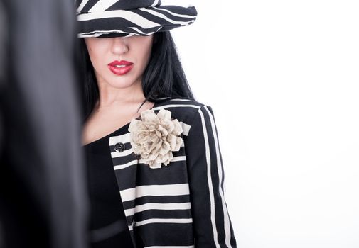 Fashion model girl posing in the studio on withe background with black and white outfit with hat