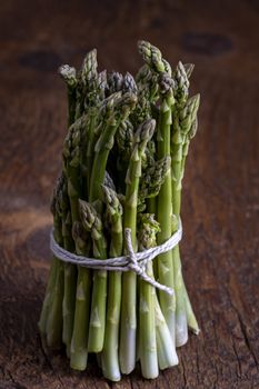 fresh green asparagus on dark wood