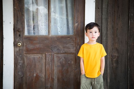 Mixed Race Chinese and Caucasian Boy Standing Alone on Porch.