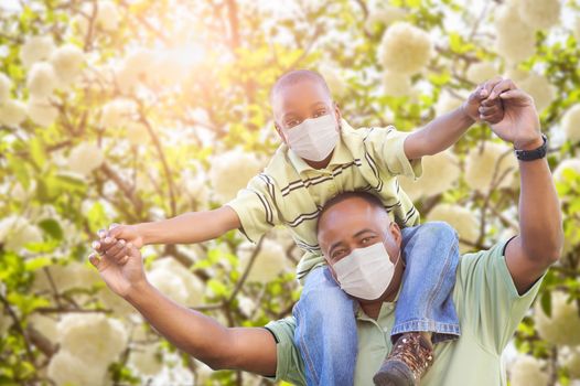 African American Father And Son Playing Outdoors Wearing Medical Face Mask.