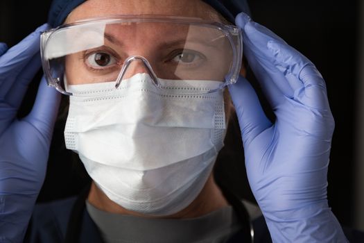 Close-Up of Female Doctor or Nurse In Medical Face Mask and Protective Gear.
