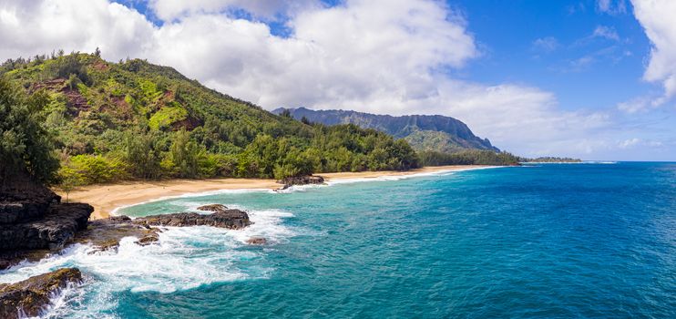 Aerial panoramic image off the coast over Lumaha'i beach on Hawaiian island of Kauai with Na Pali mountains behind