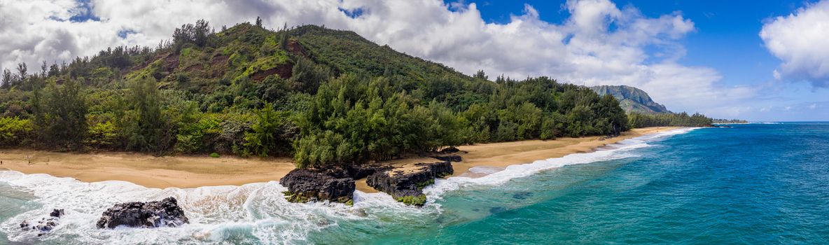 Aerial panoramic image off the coast over Lumaha'i beach on Hawaiian island of Kauai with Na Pali mountains behind