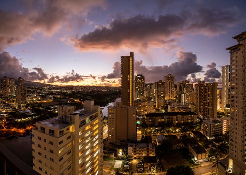Dawn or sunrise behind the hotels and apartments in the modern part of Waikiki by the canal on Oahu