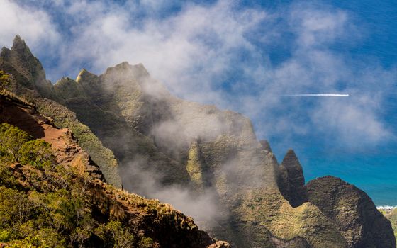 Fluted rocks of the Na Pali mountains through the clouds from Kalalau lookout on Kauai