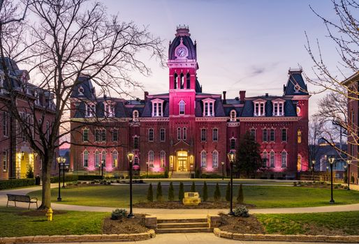 Dramatic image of Woodburn Hall at West Virginia University or WVU in Morgantown WV as the sun sets behind the illuminated historic building