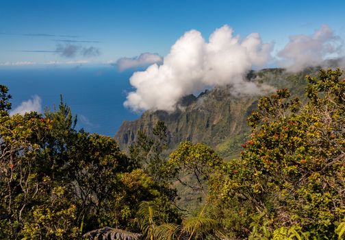 Fluted rocks of the Na Pali mountains with clouds forming over the peaks from Kalalau lookout on Kauai