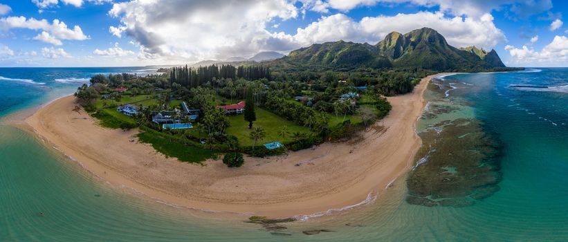 Aerial panoramic image off the coast over Tunnels beach on Hawaiian island of Kauai with Na Pali mountains behind