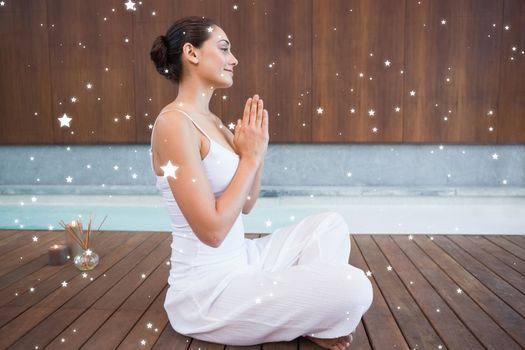 Content brunette in white sitting in lotus pose  against snow