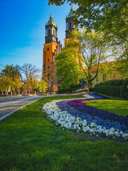 Look to small colorful garden in front of Basilica of Saint Peter and Paul in Poznan City at sunny morning